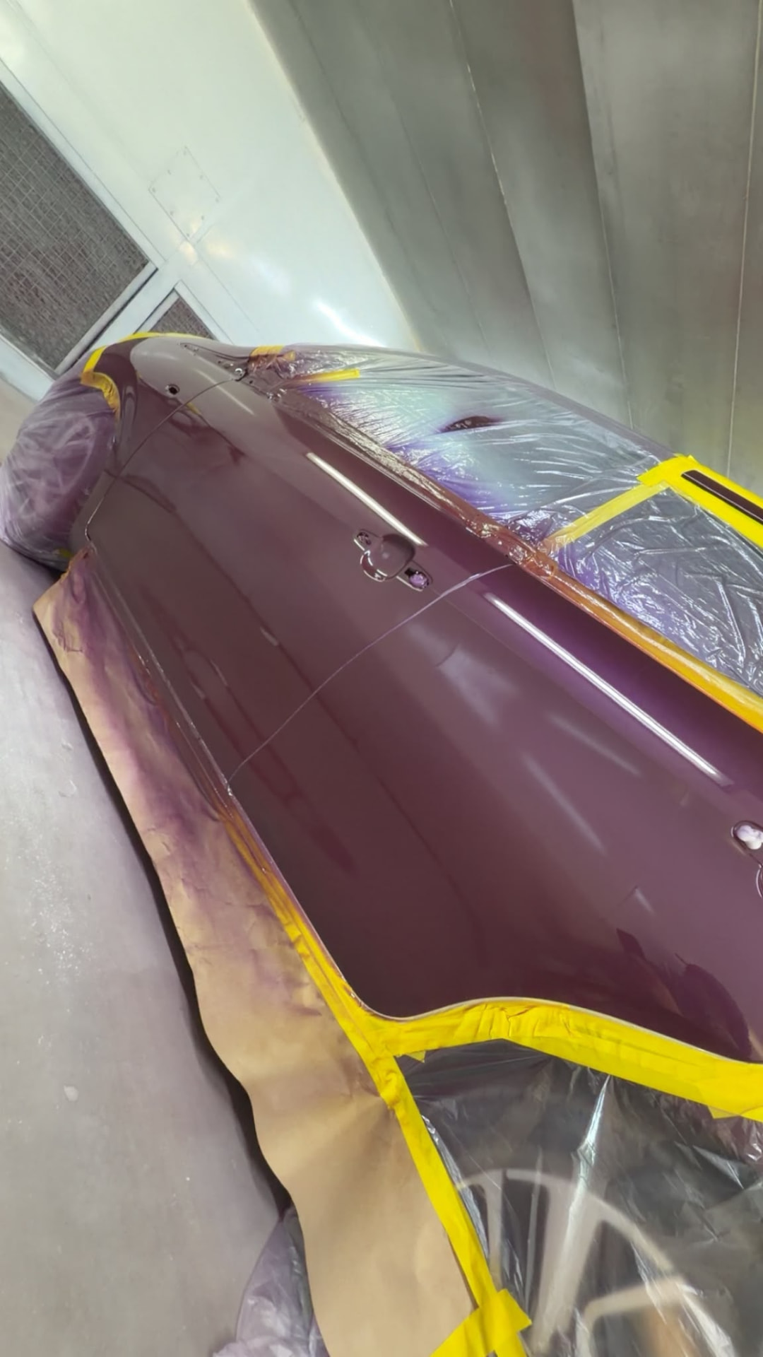 Freshly painted burgundy car side in the workshop