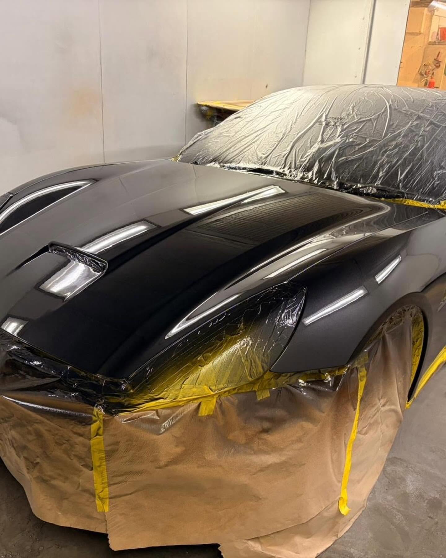 Masked sports car in the paint booth